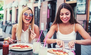 Two Women Eating Pizza Outdoors